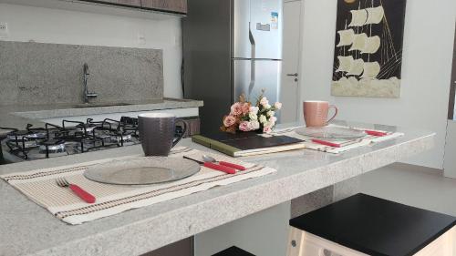a kitchen counter with a plate and a stove at Areias do Mar ! 2 Quartos Familia com Varanda A213 in Barra de São Miguel