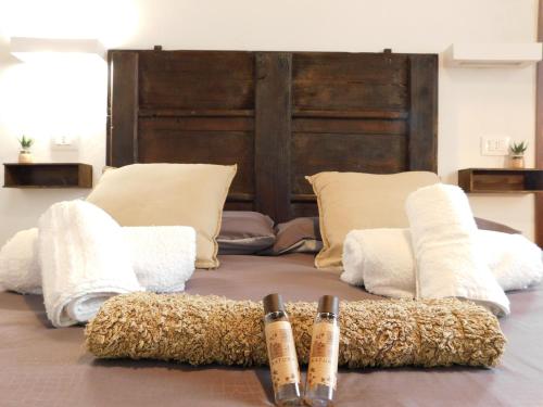 a bed with three pillows and two bats on it at Otello Guest House in Montalcino