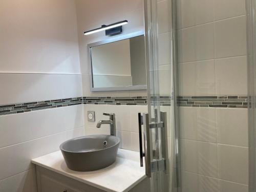 La salle de bains est pourvue d'un lavabo et d'un miroir. dans l'établissement LES PIEDS DANS L'EAU - Accès direct à la plage, à Bernières-sur-Mer