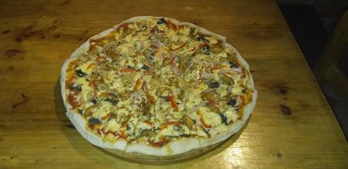 a pizza sitting on top of a wooden table at Monkeywasi Climbing Hostel in Huaraz
