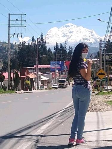 a woman is standing on the side of the road at Monkeywasi Climbing Hostel in Huaraz