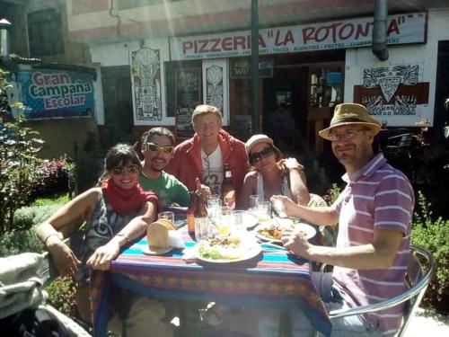 a group of people sitting around a table with food at Monkeywasi Climbing Hostel in Huaraz