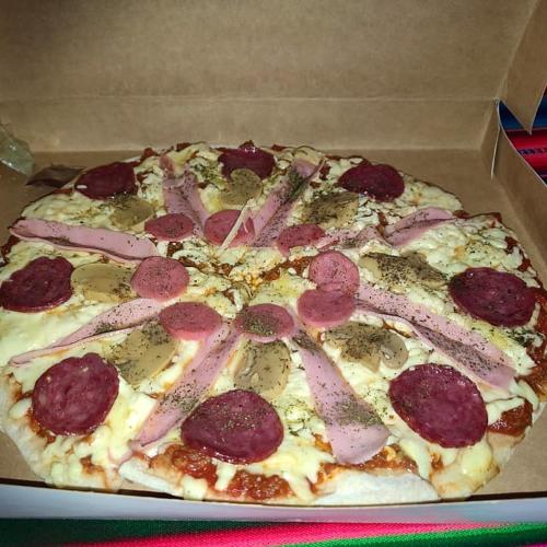 a pepperoni pizza in a box on a table at Monkeywasi Climbing Hostel in Huaraz