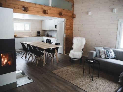 een woonkamer met een bank en een tafel met een open haard bij Kalliorinne in Kuusamo