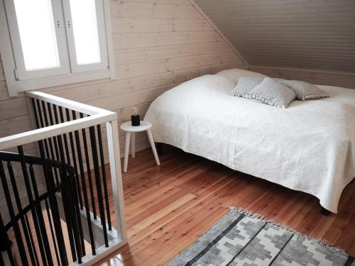 a bedroom with a white bed and a wooden floor at Kalliorinne in Kuusamo