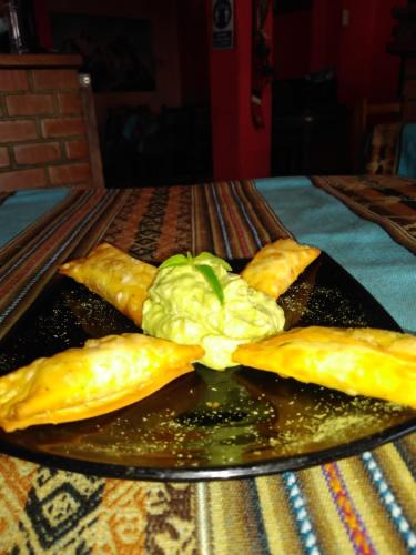 a plate with some food on a table at Monkeywasi Climbing Hostel in Huaraz