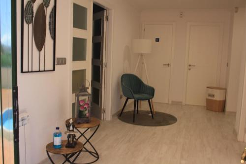 a living room with a green chair and a table at Casa A Boleriña 2 in Combarro