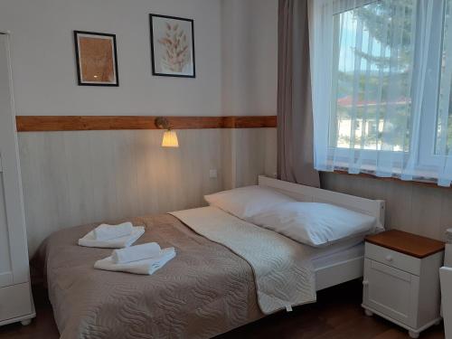 a bedroom with a bed with two towels on it at Apartamenty nad Jeziorem in Międzybrodzie Żywieckie