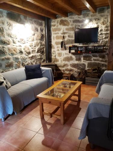 a living room with two couches and a coffee table at La Cabaña del Río in San Roque de Ríomiera