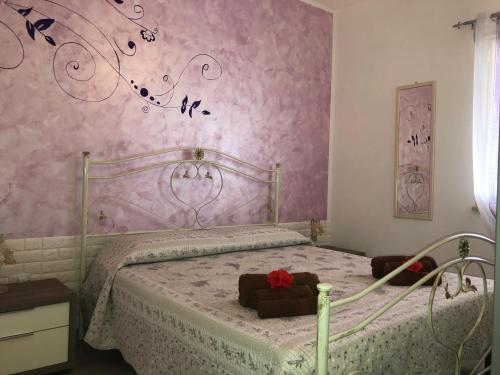 a bedroom with a bed with a pink wall at Residenza San Michele in Tropea
