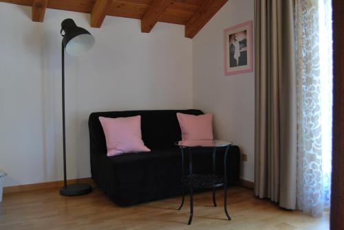 a living room with a black couch with pink pillows at B&B Casa Val in Quincinetto