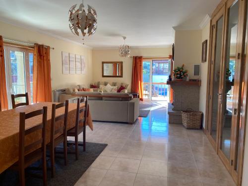 a living room with a table and a couch at Beautiful detached villa with private pool, Fibre Wi-fi, garden, games room & BBQ in Terras de Bouro