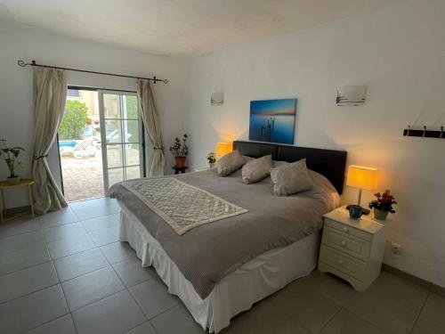 1 dormitorio con 1 cama grande y 2 lámparas en Spacious 3 bedroom villa with pool en Luz