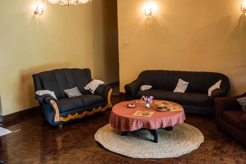 a living room with two chairs and a coffee table at Kiwavi Home in Moshi