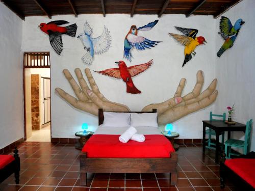 a bedroom with a mural of birds on the wall at La Hacienda in San Gil