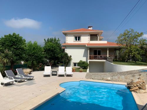 a villa with a swimming pool and a house at Beautiful detached villa with private pool, Fibre Wi-fi, garden, games room & BBQ in Terras de Bouro