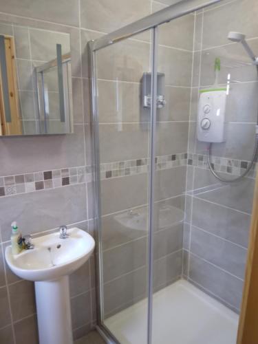 een badkamer met een douche en een wastafel bij Old School House Belcoo (43) in Belcoo
