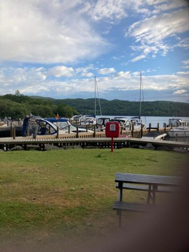 a bench sitting in front of a marina with boats at Troutbeck Hot Tub Lodge 4 in Windermere