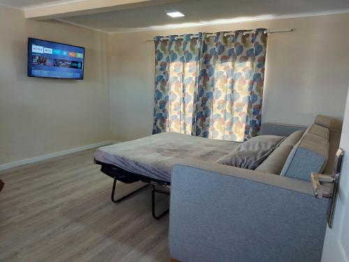 a bedroom with a bed and a couch in a room at Lovely Cozy Keito in Palm-Eagle Beach