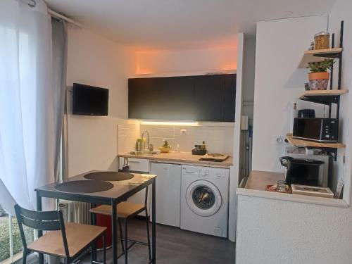 une cuisine avec une table et une machine à laver dans l'établissement Studio Gruissan La Presqu'île 2, à Gruissan