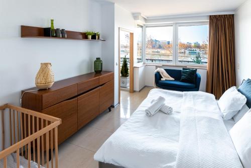 ブダペストにあるDunapest Apartmanのベッドルーム1室(ベッド1台、椅子、窓付)