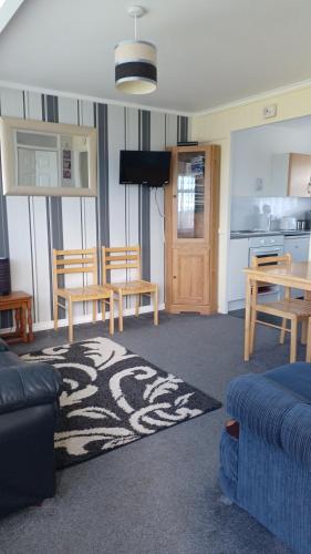 a living room with a couch and a table and a kitchen at alicias chalets in Great Yarmouth