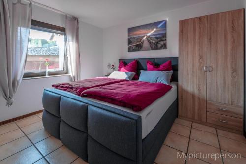 a bedroom with a large bed with a red comforter at Ferienwohnung Elsa in Nideggen
