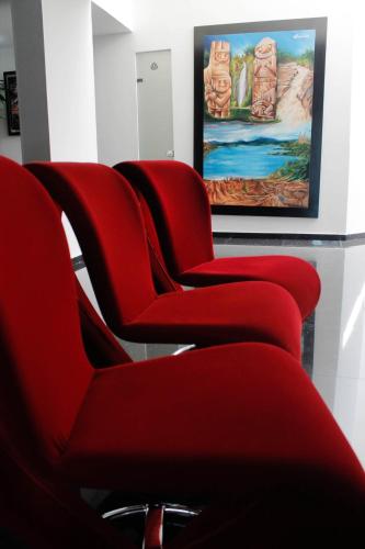 a row of red chairs in a waiting room at La Cabrera Hotel Boutique in Neiva