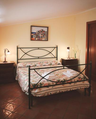 a bedroom with a bed and two lamps and a picture on the wall at Bed & Breakfast Spigolatrice in Sapri