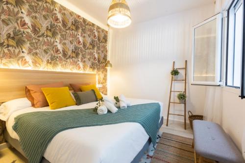 a bedroom with a bed with yellow and green pillows at ENTREARCOS in Cádiz