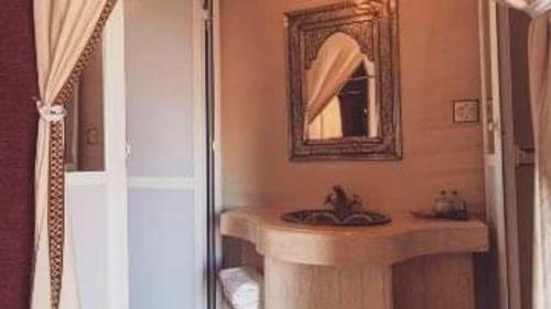 a bathroom with a sink and a mirror at Erg Chebbi Luxury Camp in Merzouga