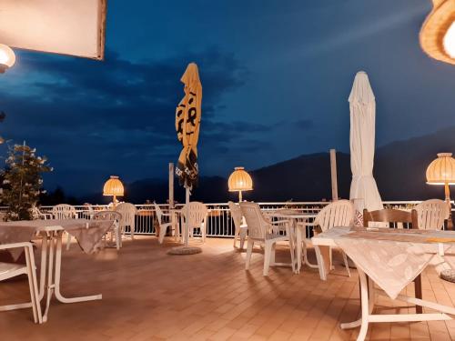 a row of tables and chairs on a deck at night at Hotel Mirabeau in Bellagio
