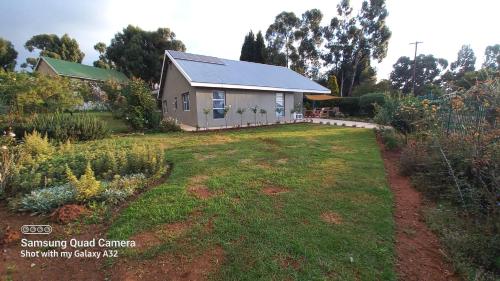 a house with a garden in front of it at SiriMiri Cottage Dullstroom in Dullstroom