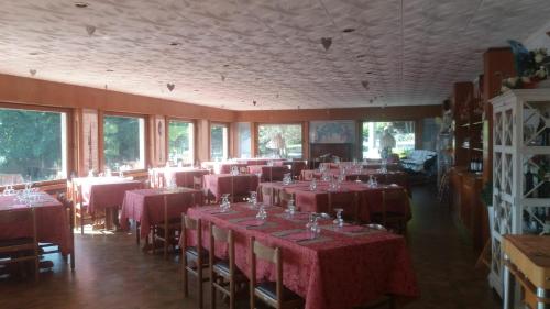 a dining room with red tables and chairs and windows at Hotel Mirabeau in Bellagio