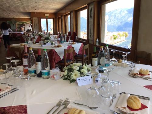 a dining room with tables with white linens and bottles at Hotel Mirabeau in Bellagio