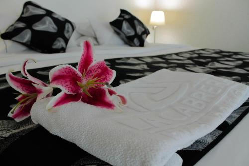 a pink flower sitting on top of a white towel at La Cabrera Hotel Boutique in Neiva