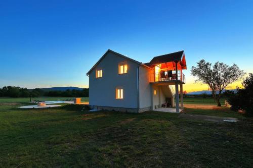 Casa pequeña con balcón en un campo en Holiday House Aurora Borealis en Ervenik