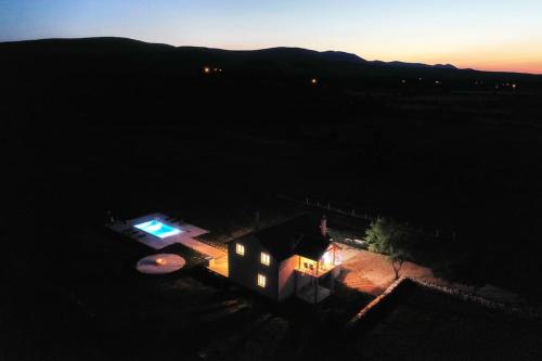 una pequeña casa por la noche con las luces encendidas en Holiday House Aurora Borealis en Ervenik