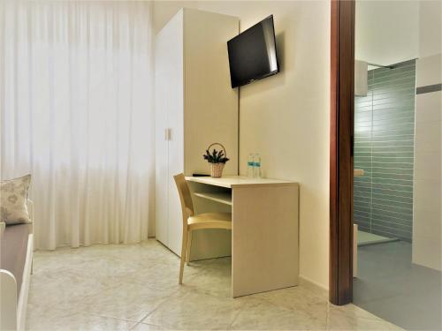a room with a desk with a tv on the wall at Innsud in Nardò