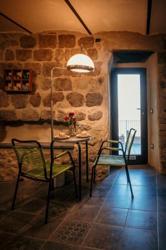 a table and chairs in a room with a stone wall at B&B La Castellina in Abbadia San Salvatore