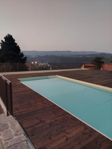 a swimming pool on top of a wooden deck at Casa das Ameias in Vouzela