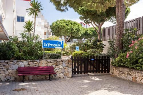 un panneau de rue assis à côté d'un banc rouge du parc dans l'établissement Studio Gruissan La Presqu'île 2, à Gruissan