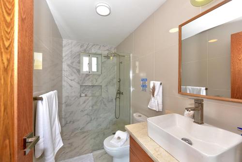 a bathroom with a sink and a toilet and a shower at Amazing ocean view apartment with grand pool in Cabarete