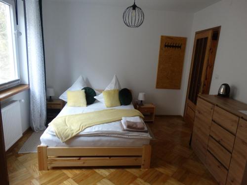 a bedroom with a bed and a dresser in it at Dom nad potokiem - pokoje całoroczne in Wołkowyja