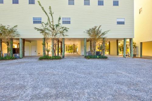 a large white building with trees in front of it at Beach Blessings Luxe 30A Townhome 2BR 3Bath, Walk to Beach, Pool, Hot Tub in Santa Rosa Beach