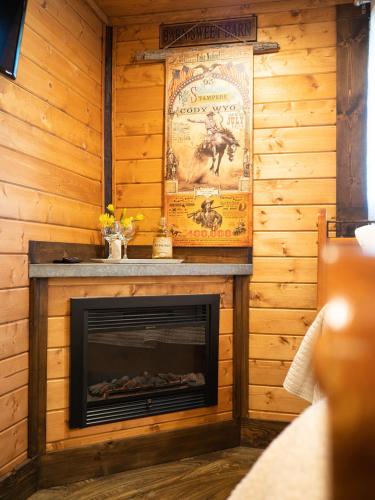 a fireplace in a log cabin with a poster at Z Ranch in Templeton