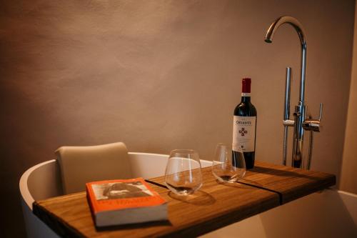 a bottle of wine and two glasses on a table at B&B La Castellina in Abbadia San Salvatore