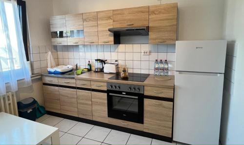 a kitchen with wooden cabinets and a white refrigerator at Zimmer für Monteure, Handwerker oder Reisende in Essen