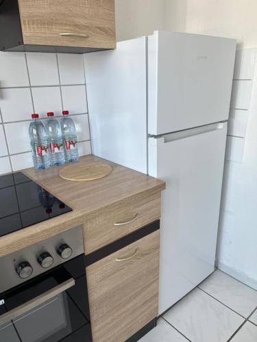 a kitchen with a white refrigerator and some water bottles at Zimmer für Monteure, Handwerker oder Reisende in Essen