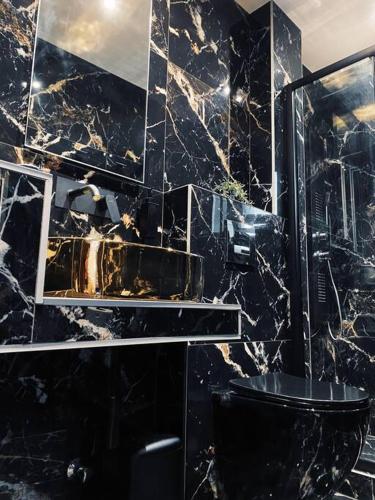 a black marble bathroom with a toilet and a shower at thesstay Attica downtown boutique apartment in Thessaloniki